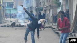 FILE: A Kashmiri protestor throws a stone towards Indian government forces during clashes in Srinagar.