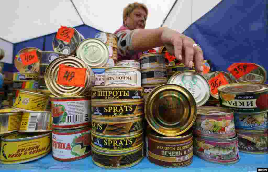 Продавец предлагает консервы на агропромышленной выставке "Агрорус" в Санкт-Петербурге