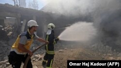 Идлиб провинциясында әуе шабуылынан соң өртенген ғимаратты сөндіріп жатқан өрт сөндірушілер. Сирия, 4 қыркүйек 2018 жыл.