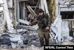 Украинский солдат ищет тела погибших в аэропорту Донецка в октябре 2015 года.