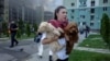 A Ukrainian woman with her dogs leaves the site of a Russian air strike on Kharkiv on July 24. 