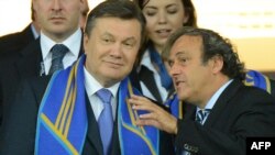 Президент УЄФА Мішель Платіні спілкується з Президентом України Віктором Януковичем під час матчу Україна – Швеція, Київ, 11 червня 2012 року