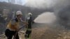 Syrian firefighters try put out a fire in a building that was hit by reported Russian air strikes in the rebel-hold town of Jadraya, about 35 kilometers southwest of the city of Idlib, on September 4.