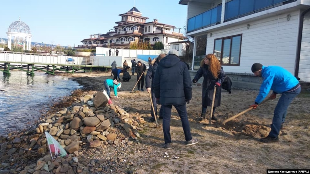 Activists remove grass that they believe was purposely planted on a beach in Rosenets Park in an effort to cement its status as "agricultural land."