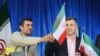 Ahmadinejad (left) handing an Iran flag to Mashaei, his vice president, in Semnan, Iran, on April 11, 2013.