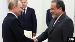 Rusiya Prezidenti Vladimir Putin və İranın xarici işlər naziri Abbas Araqçi Kremldəki görüş zamanı əl sıxırlar. 2025