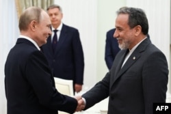 Президент Росії Володимир Путін (ліворуч) та міністр закордонних справ Ірану Аббас Аракчі потискають один одному руки під час зустрічі в Кремлі, Москва, 23 червня 2025 року