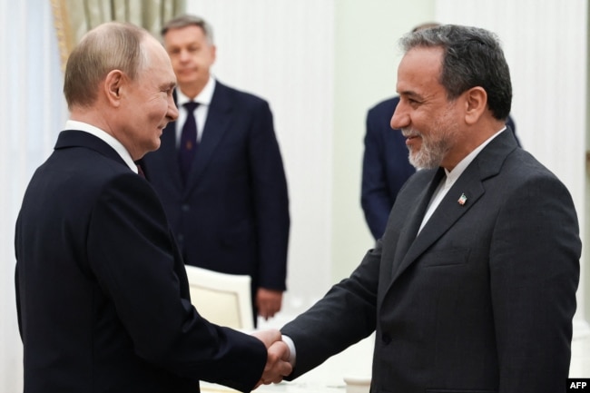 Russia's President Vladimir Putin (left) and Iranian Foreign Minister Abbas Araqchi shake hands during a meeting at the Kremlin in Moscow on June 23.