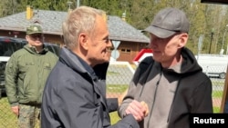 Прэм'ер-міністар Польшчы Дональд Туск (у цэнтры) вітае Анджэя Пачобута на мяжы