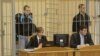 Dzmitry Kanavalau (left) and Ulad Kavalyou are seen in the defendants' cage before court hearings in Minsk on September 15, 2011.