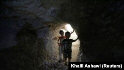 SYRIA -- Children walk in a makeshift shelter in an underground cave in Idlib, Syria September 3, 2018. Picture taken September 3, 2018.