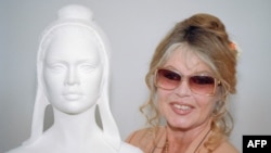 Бриджит Бардо позира до бюста на Мариан, символ на Френската република, за който преди това актрисата е била модел, Париж, 11 май 1993 г.