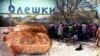 Колаж. Хліб спечений на Великдень. Позаду черга за продуктами, завезеними волонтерами