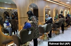 Beauticians put makeup on customers at a Kabul beauty salon in April 2021. The Taliban has now closed all beauty salons.