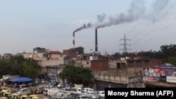 Smoke billows from two smokestacks at the coal-based Badarpur Thermal Station in New Delhi.
