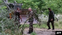 Soldiers of the Hungarian Army's technical unit prepare the first section of a metal fence at the Hungarian-Serbian border near the village of Morahalom on July 13.