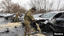 Ushtarët rusë duke marrë pjesë në operacione pastrimi, pas atij që autoritetet lokale e cilësuan si sulm raketor ukrainas në Belgorod, Rusi, 17 mars.