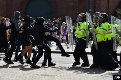 Oficerët e policisë përballen me protestues në Liverpul, Angli, më 3 gusht 2024, gjatë një proteste të mbajtur kundër sulmit me thikë në Southport, më 29 korrik. Europe Invasion sugjeroi rrejshëm se sulmuesi ishte një “imigrant mysliman”, ndërsa shefi i policisë së Londrës deklaroi se trazirat ishin “nxitur nga dezinformimi”.