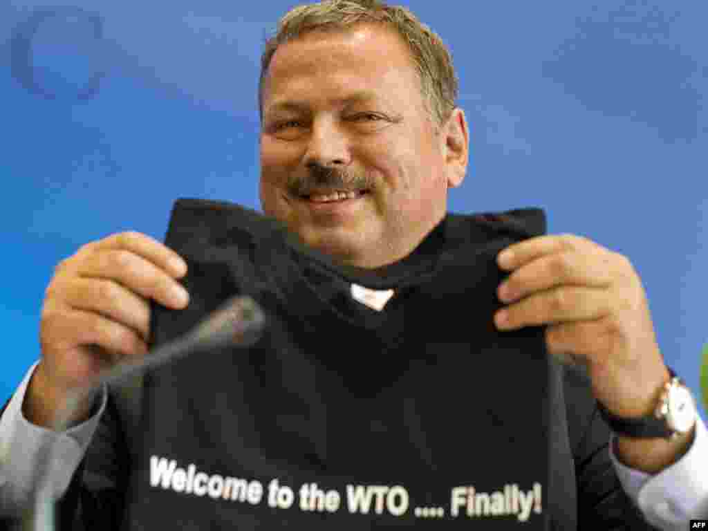 Russian chief negotiator Maxim Medvedkov smiles with a T-shirt he received after formal negotiations on Russia's membership bid to join the World Trade Organization in Geneva. (Photo for AFP by Fabrice Coffrini)