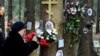 A woman fastens flowers to a tree with portraits of victims of Soviet dictator Joseph Stalin's purges at the memorial where the victims were buried in the woods on the outskirts of St. Petersburg, on October 30.