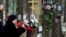 A woman fastens flowers to a tree with portraits of victims of Soviet dictator Joseph Stalin's purges at the memorial where the victims were buried in the woods on the outskirts of St. Petersburg, on October 30.