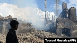 A young Kashmiri villager looks at the remains of a house destroyed during a deadly gunbattle between militants and Indian government forces in the Pulwama district south of Srinagar on March 5.