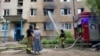 Жительница возле поврежденного российским авиаударом дома в Славянске
