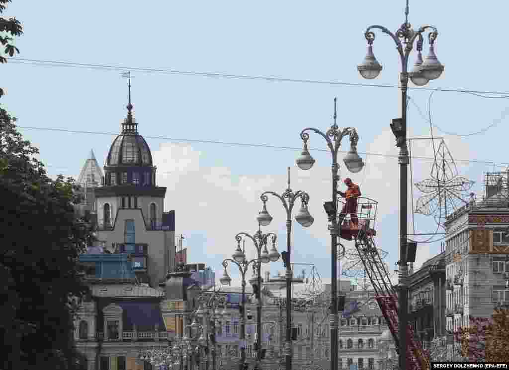 Municipal workers fix public lighting above the central street of Khreshchatyk in Kyiv.(epa-EFE/Sergey Dolzhenko)