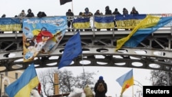 Pro-EU protesters stand guard at a barricade in central Kyiv on December 13.