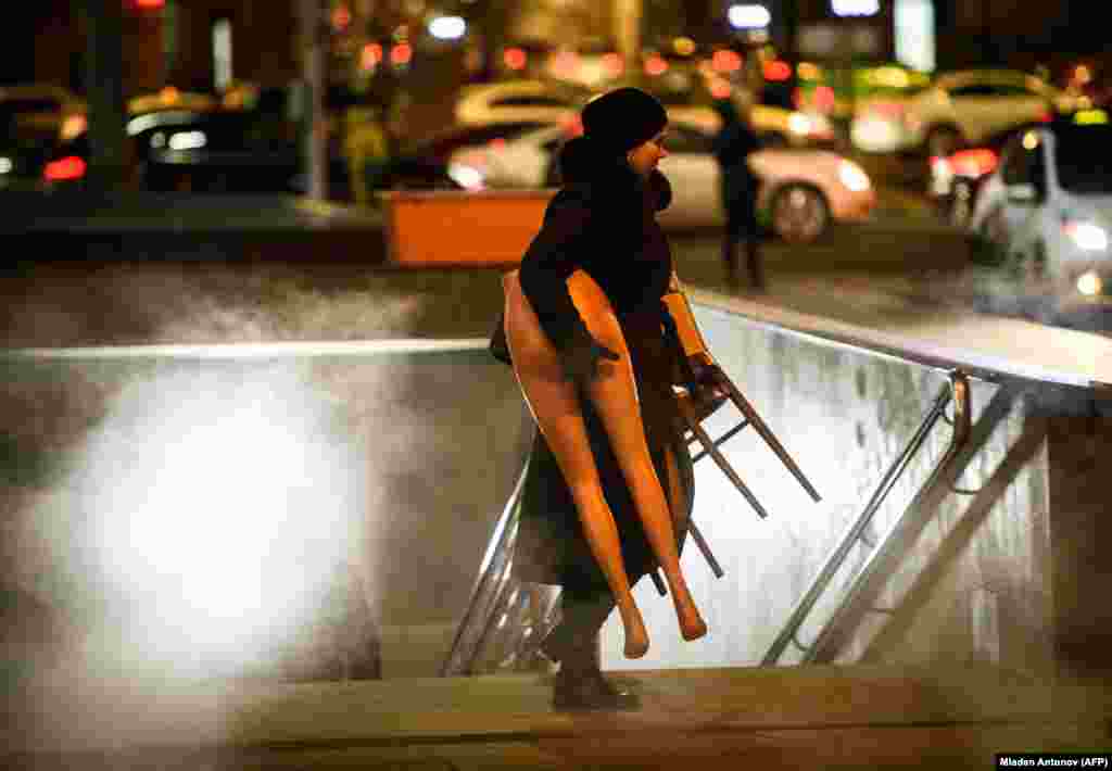 A woman carries half a mannequin as she emerges from an underground passage in central Moscow, Russia. (AFP/Mladen Antonov)