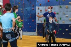 Constantin Voicescu, kinetoterapeut și instructor la Climb Again le explică copiilor cu deficiențe de vedere mișcările corecte în timpul sesiunii de încălzire, la Centrul Climb Again din București.