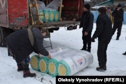 Представители Норвежского совета по делам беженцев развозят материалы для утепления