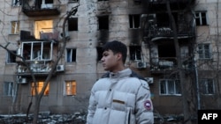 A resident stands next to an apartment building damaged in a Russian drone attack in Odesa on January 17.