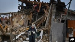 Banorët bartin gjërat personale të mbetura pas shkatërrimit nga sulmi ajror në Zaporizhja të Ukrainës