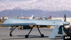 Un aparat dron US Predator, dotat cu rachete, gata de decolare. Baza militară din Bagram, Afghanistan