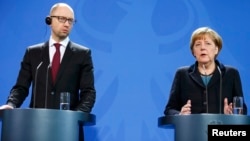 Ukrainanyň premýer-ministri Arseniý Ýatsenýuk (çepde) we Germaniýanyň kansleri Angela Merkel.