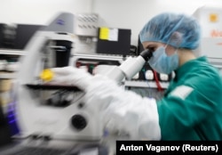 Një shkencëtar duke ekzaminuar qelizat e infektuara me COVID-19, nëpërmjet një mikroskopi, gjatë hulumtimit për një vaksinë kundër koronavirusit, në një laborator, në Shën Pjetërburg, Rusi, më 20 maj 2020.