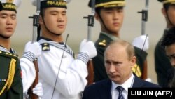 Russian Prime Minister Vladimir Putin walks past an honor guard after arriving in Beijing in October 2011.