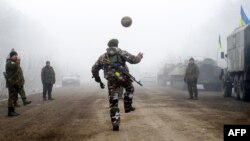 Украинские военные играют в мяч на трассе Артемовск-Дебальцево. Снимок Владимира Шуваева.