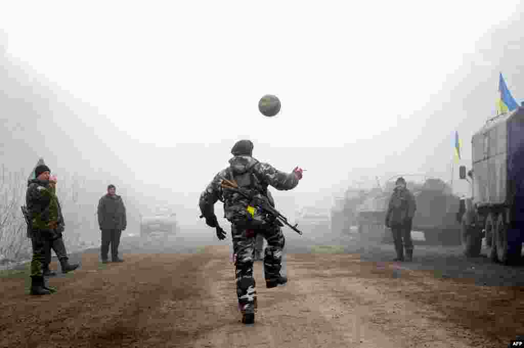 Ukrainian servicemen play football on a road near Debaltseve on February 15 shortly after a cease-fire began to be cautiously observed by both pro-Russian rebels and Kyiv forces in the country's months-long conflict. (AFP/Volodomyr Shuvayev)