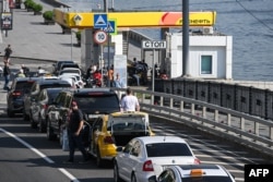 Șoferii stau la coadă, așteptând să-și alimenteze mașinile la o benzinărie Rosneft din Moscova, pe 3 iulie 2026. Criza de carburanți ar fi, potrivit unor comentatori de presă, prima mare încercare internă pentru Putin, de la începerea războiului.