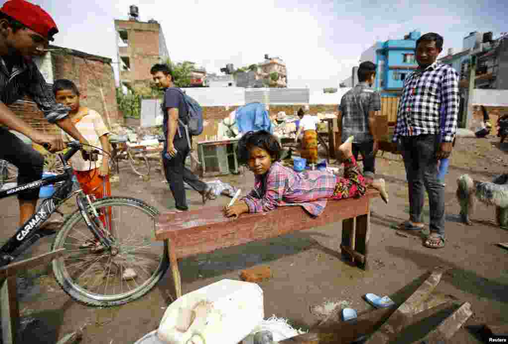 A girl lies on a bench near the bank of the Bagmati River after floodwaters caused by heavy rainfall entered a slum in Kathmandu, Nepal. (Reuters/Navesh Chitrakar)