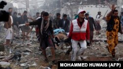 Yemeni medics and rescue workers carry a body on a stretcher at the site of reported airstrikes by Saudi-led coalition planes in the capital Sanaa on October 8.