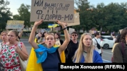 Учасниця протестної ходи проти відставки Михайла Федорова з українським прапором і плакатом «Ми вимагаємо не так багато – Федоров МО». Дніпро, 31 липня 2026 року 