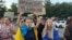 Учасниця протестної ходи проти відставки Михайла Федорова з українським прапором і плакатом «Ми вимагаємо не так багато – Федоров МО». Дніпро, 31 липня 2026 року 