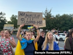 Учасниця протестної ходи проти відставки Михайла Федорова з українським прапором і плакатом «Ми вимагаємо не так багато – Федорів МО». Дніпро, 31 липня 2026 року