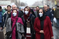 Iranian women wearing protective masks in Tehran on February 20. Some Iranians have questioned whether officials are being transparent about the extent of the outbreak in the country.