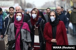 Iranian women wearing protective masks in Tehran on February 20. Some Iranians have questioned whether officials are being transparent about the extent of the outbreak in the country.