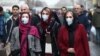 Iran -- Iranian women wearing protective masks to prevent contracting a coronavirus walk at Grand Bazaar in Tehran, February 20, 2020