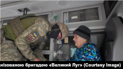 Медик 65-ї окремої механізованої бригади «Великий Луг» оглядає Еллу Хвостенко
